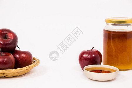 以白色背景隔离的苹果红和蜂蜜碗图片