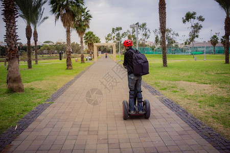 男人在公园骑电动车背影图片