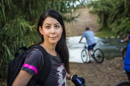 妇女骑自行车在农村看摄影机图片