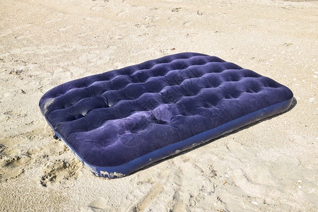 在池塘中游泳的蓝色充气床垫在海滩上游泳的蓝色充气床垫图片