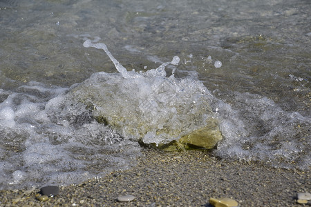 海浪在岸上泡和石头覆盖海浪在岸上泡和石头覆盖图片