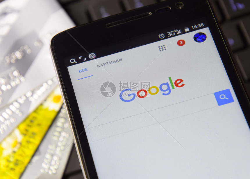 俄罗斯Poltavskaya村2016年月3日智能手机在键盘背景上使用谷歌搜索系统在谷歌的帮助下查找信息在键盘背景上使用谷歌搜索图片