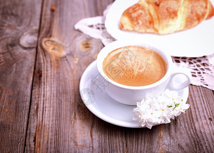 灰木背景的咖啡杯和羊角面包最高视图图片