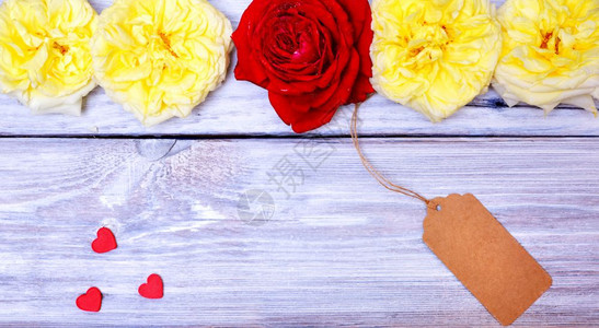 白木背景上的一根绳子玫瑰和纸标签图片