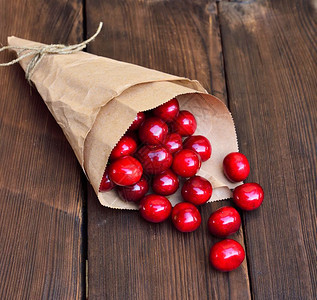 褐木背景纸袋里的红樱桃图片