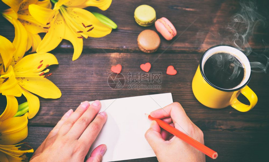 一杯咖啡和两只手拿着红铅笔的女手图片