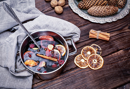 烹煮在钢铁锅中葡萄酒加香料和水果在棕色木底顶层风景图片