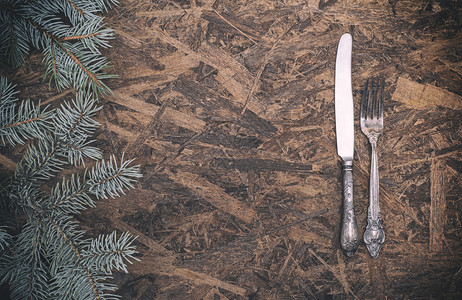 棕色木背景的旧铁叉和刀中间空侧观绿色树枝图片