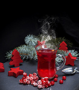 在黑色背景的透明玻璃杯中用清茶从新鲜的红色生菜中提取出来图片