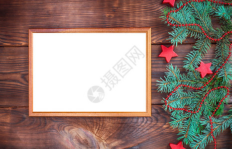 棕墙上的空木框紧靠绿树枝和圣诞装饰图片