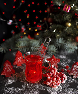 在黑色背景的透明玻璃杯中用清茶从新鲜的红色生菜中提取出来图片