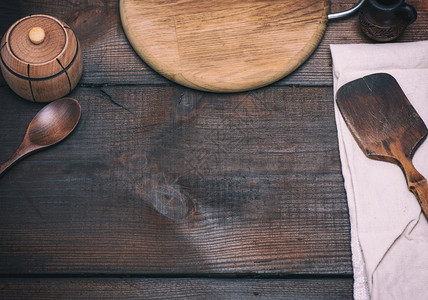 木制厨房抹刀和圆形砧板背景为棕色中间空旷图片