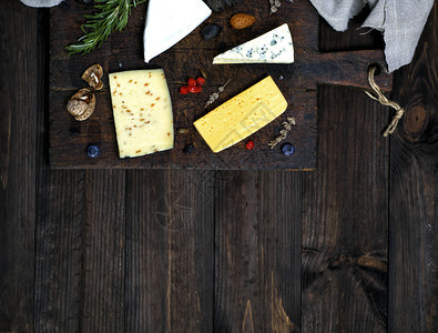 棕色切割板上的奶酪块罗克福特布里带核桃的奶酪顶视图底层空间图片