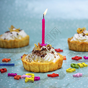 节日甜蜜蛋糕粉红色的烧蜡烛和彩字母图片