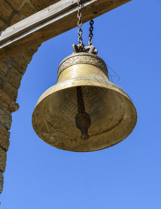 一根大铜铃挂在木形十字横梁上看底部一只大铜铃挂在木形十字横梁上图片