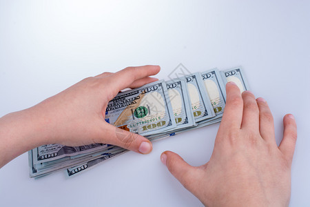 人类手中持有美元钞票作为白纸上孤立的金钱图片