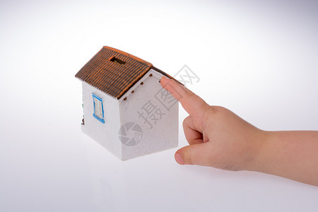 皲裂的小手用小手指着一个白色背景的模范房子背景