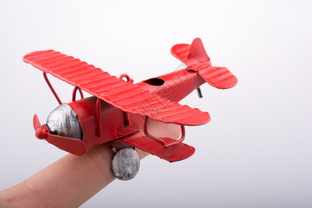 手中拿着一架红色玩具飞机图片