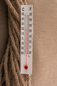 温度计放置在布背景的棕色绳子上图片