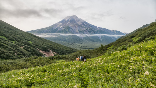 科里亚克堪察特卡山脉和火堪察特卡佩宁山脉和火的美景堪察特卡半岛的美景阳光明媚的日子里山地脉湖和蓝天云层的夏季全景欧拉西亚俄罗斯远东堪察特背景