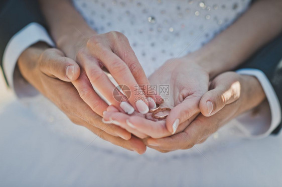 男人和女手握结婚戒指图片