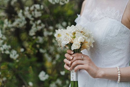 美丽的婚礼花束放在新婚夫妇手上礼图片