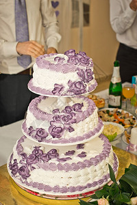 三个圆圈的婚礼蛋糕配有紫罗兰色的油图片