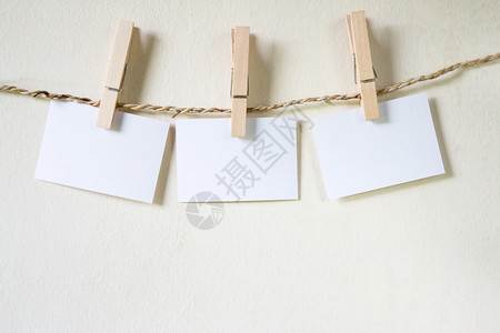 三个空白纸方格与一根字符串清洗线挂钩后面有木板栅栏三个空白纸方格w图片