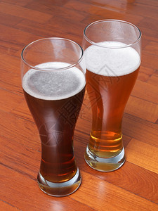两杯德国黑白西化啤酒在地板上为浪漫约会图片