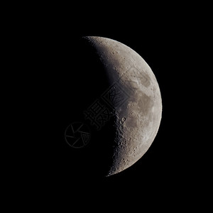 第一季月亮夜间用望远镜从北半球观测到的黑天上的第一个四分之一月亮图片