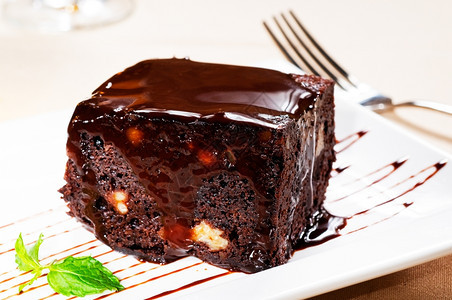 美味的巧克力和胡桃蛋糕边有薄荷叶图片