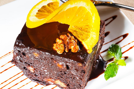 美味的巧克力和胡桃蛋糕上面和薄荷叶加一片奥兰斯图片