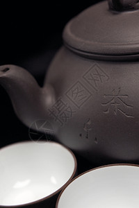 瓷菊茶壶和黑杯子图片