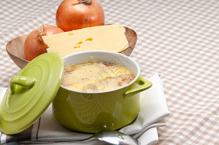 洋葱汤加泥锅上面有融化的奶酪和面包图片