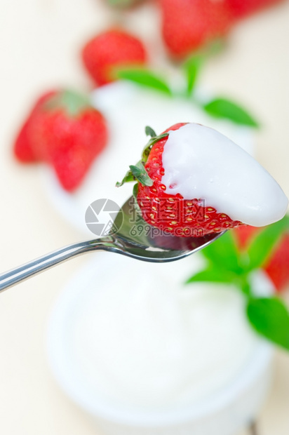 拿勺子挖酸奶和草莓图片