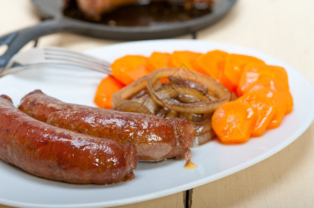 用胡萝卜和洋葱烤在铁棍上煮的牛肉香肠图片