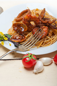 红番茄酱加白锈木桌上的意大利海鲜面图片