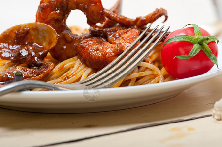 红番茄酱加白锈木桌上的意大利海鲜面图片