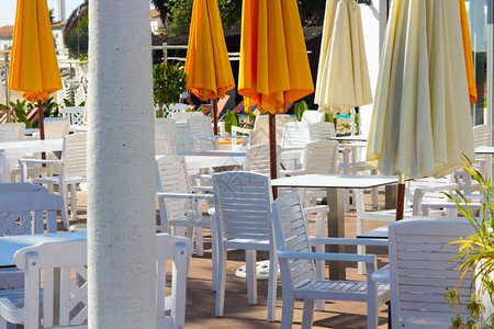 白椅子和带雨伞的桌橙色图片