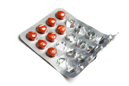 红色药丸包装在白背景的孤立泡中图片