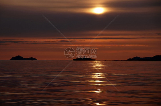 海红天空和水中的日落出图片