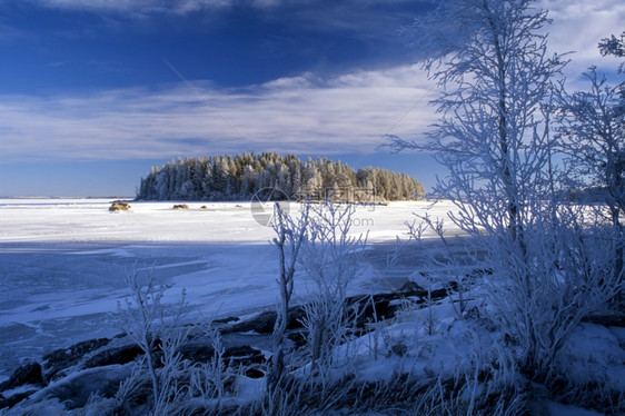 与一个小岛的冰冻湖蓝天和阳光图片