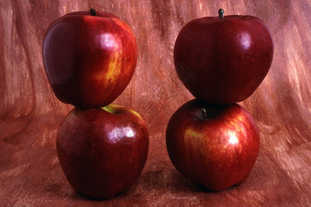 四个红苹果在涂漆背景上被孤立图片