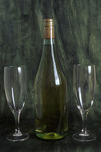 一瓶酒和两杯子在涂漆背景上隔绝图片