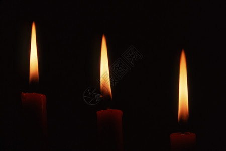 黑暗背景的三根蜡烛图片