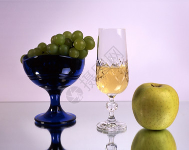一杯含水果的葡萄酒在镜子上隔绝图片