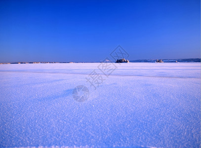 雪地草和蓝天空的景观图像图片