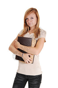 一个漂亮女人站在工作室拿着一个大书架胸口穿灰色牛仔裤和米毛衣白背景图片