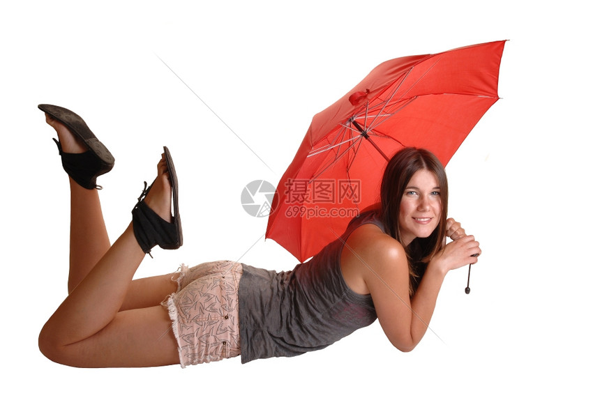 一个青少年躺在她的肚子上躺在地板穿着粉红色短裤和灰的顶部拿着红伞对镜头微笑图片