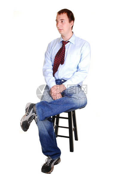一个穿牛仔裤和蓝衣衬衫的青少年身着领带坐在本校的椅子上与外界隔绝白人背景隔绝图片